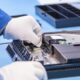 Technician repairing a PS4 console in Dubai with tools on a clean workbench