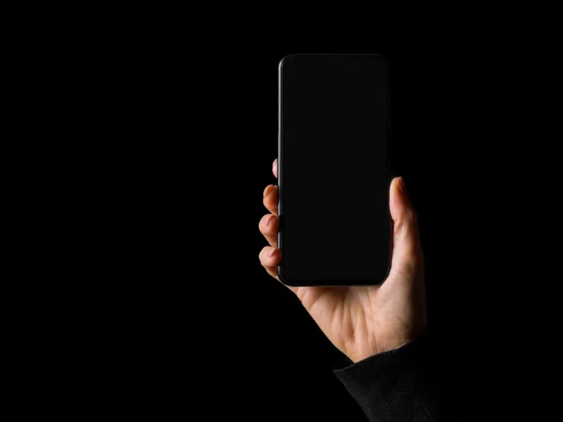 Technician fixing black screen on iPhone display.