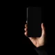 Technician fixing black screen on iPhone display.