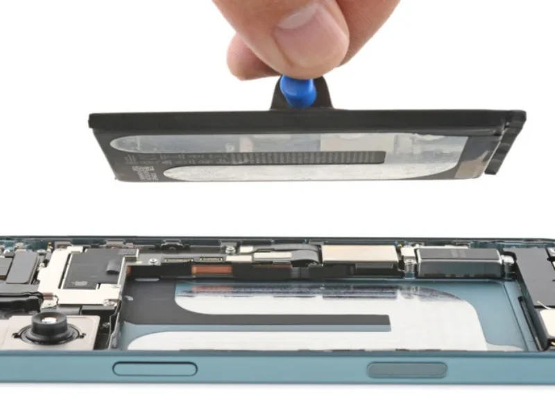 Technician testing an iPhone 16 battery draining fast issue at a repair shop in Dubai.