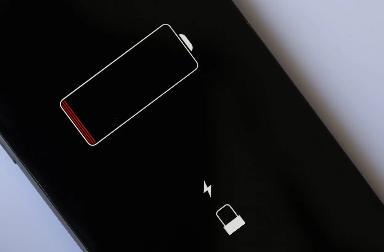 Technician checking iPhone battery draining fast causes and applying fixes.