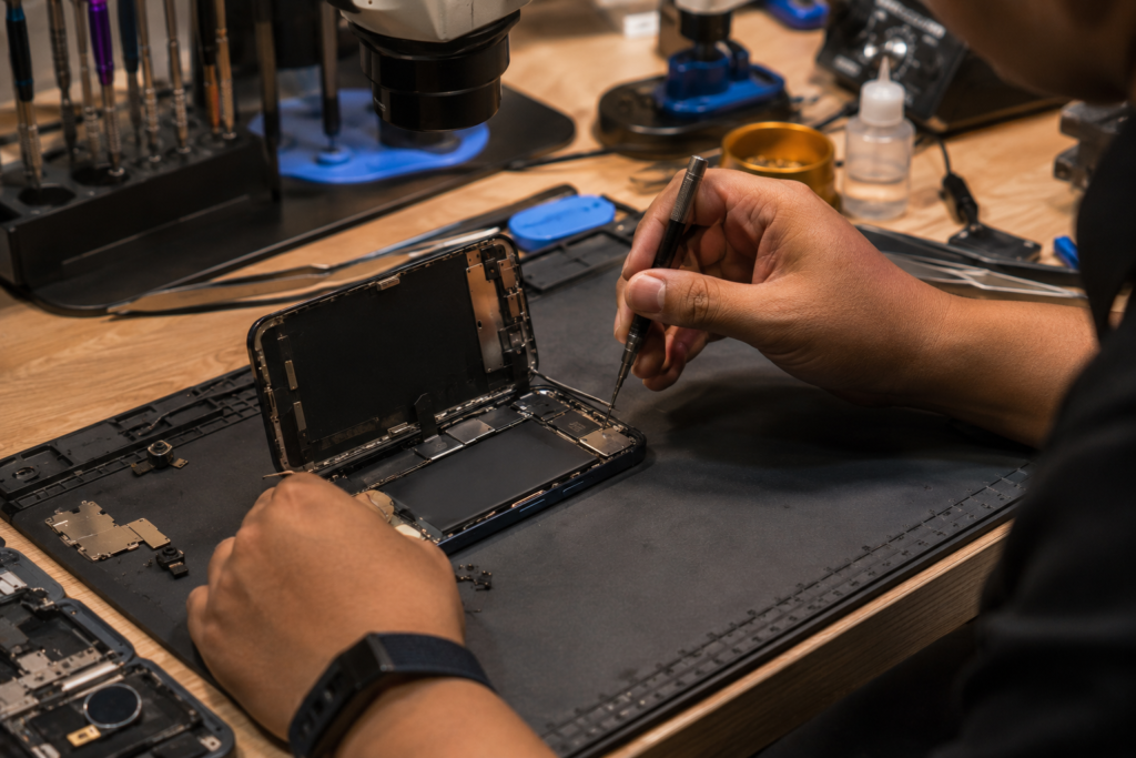 Technician working on an opened smartphone motherboard for data recovery